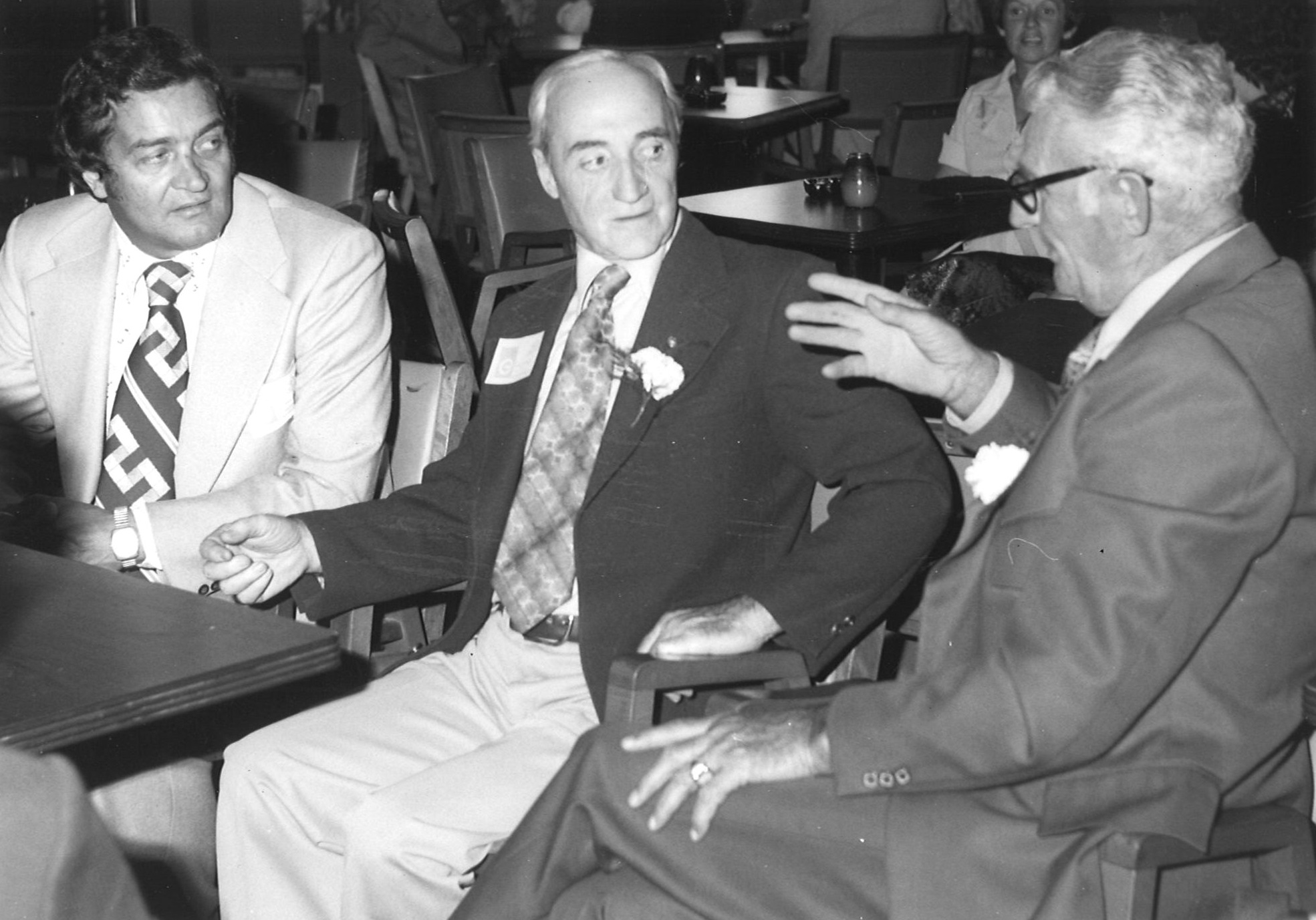 Trois hommes assis, en discutions lors de l'Assemblée des Maitres Électriciens.  
